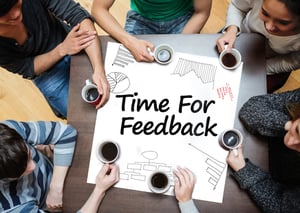 Time for feedback written on a poster with drawings of charts during a brainstorm